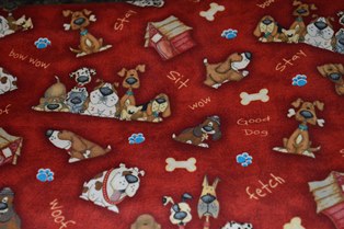 Fabric with various dog breeds on it. Mostly dark colors - brown and black.