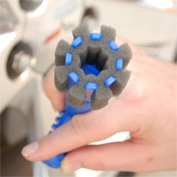 The foam brush head surrounds the lug nut to completely clean it.